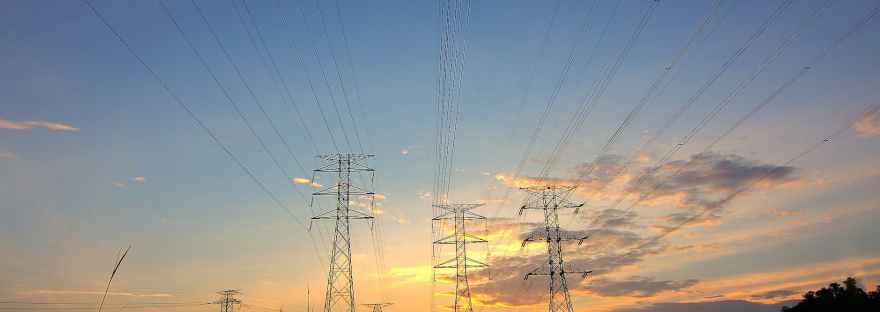 three black metal electricity posts during golden hour