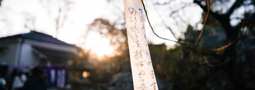 a white cloth with japanese calligraphy hanging on a stem